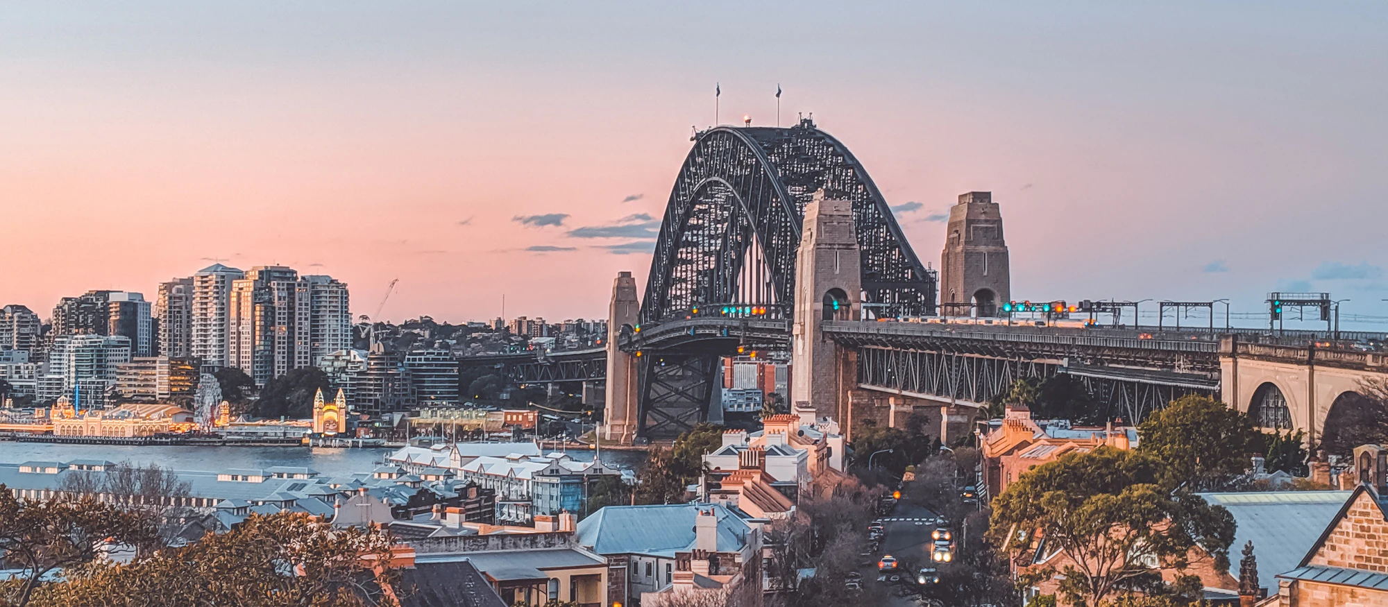 The Sydney Harbour Bridge at dusk, with traffic crossing the bridge deck